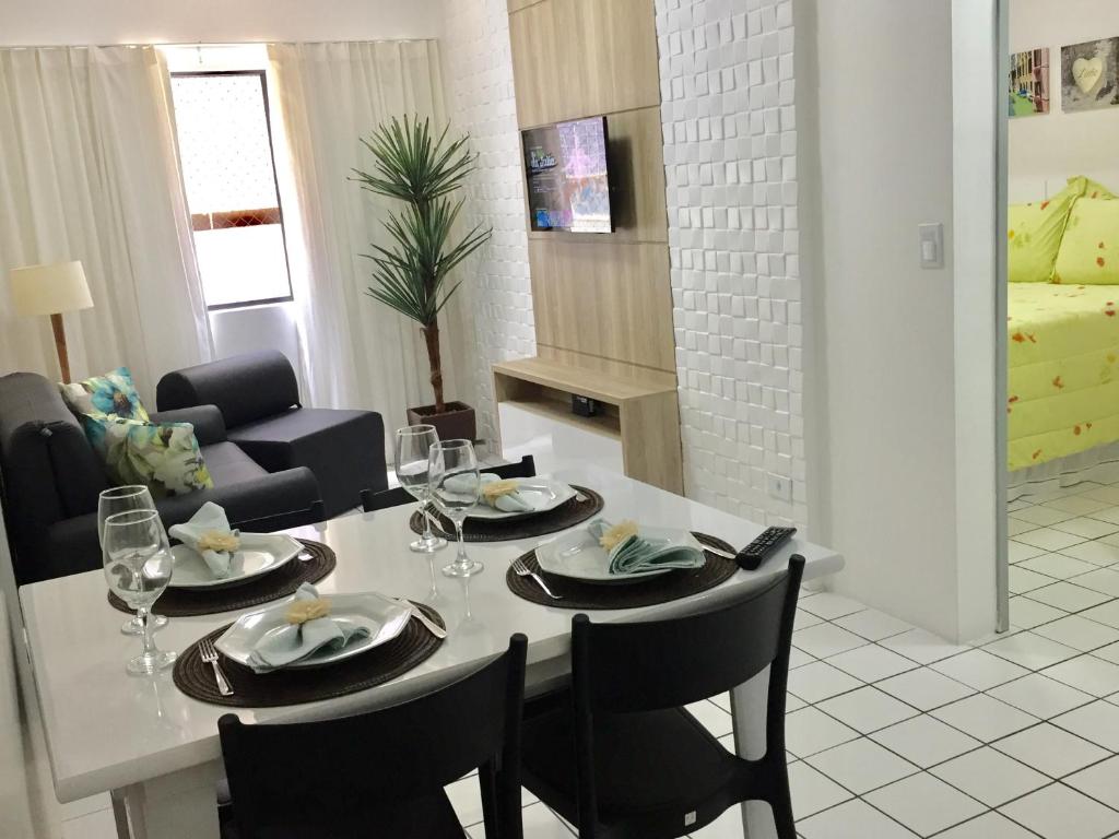 comedor con mesa y sillas con copas de vino en Apartamento Ametista 2, en Maceió
