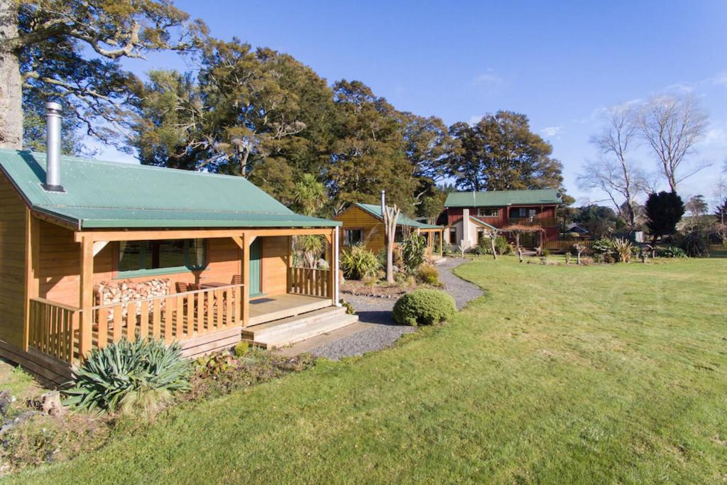 a house with a green roof and a yard at The River Lodge in Ohakune