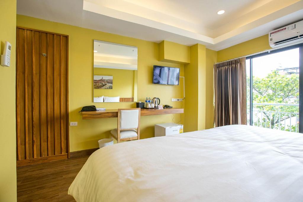 a bedroom with a bed and a desk with a chair at Chamnan Residence in Hat Yai