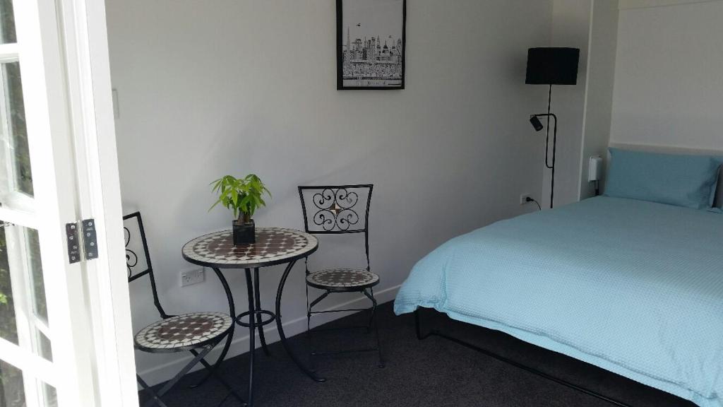 a bedroom with a bed and a table and chairs at Mauao Studio in Mount Maunganui