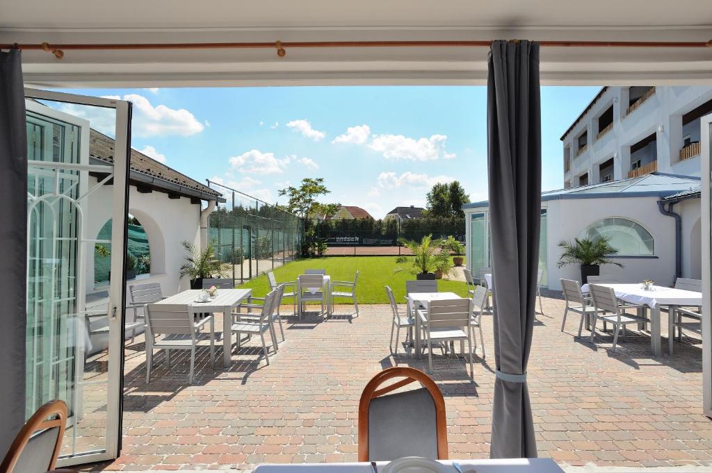 a view of a patio with tables and chairs at Sporthotel Podersdorf in Podersdorf am See