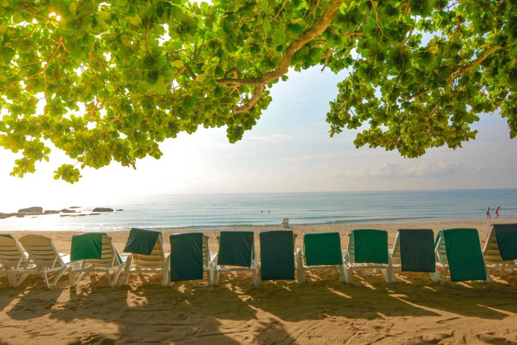 a row of lawn chairs on the beach at First Bungalow Beach Resort in Chaweng