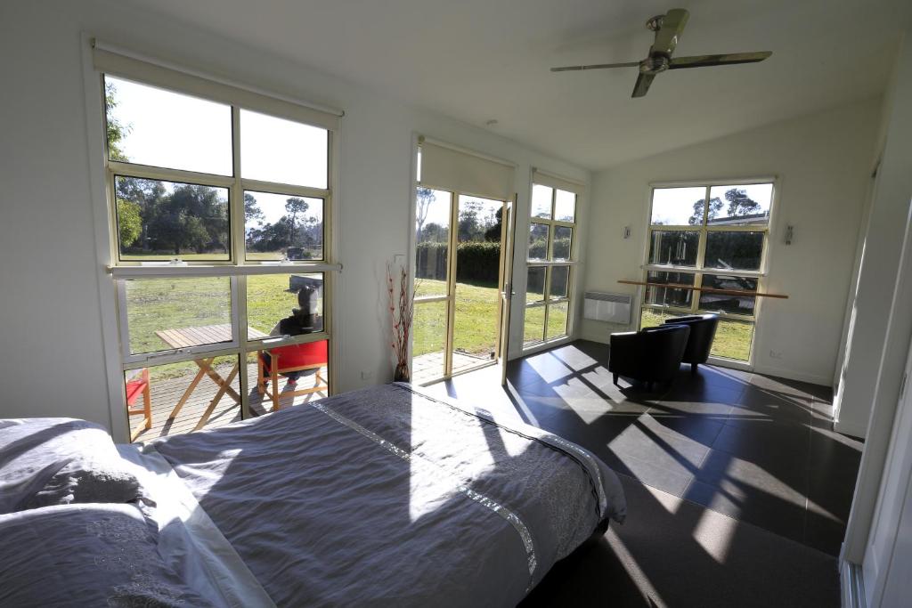 a bedroom with a bed in a room with windows at Riverwalk B&B in Robigana