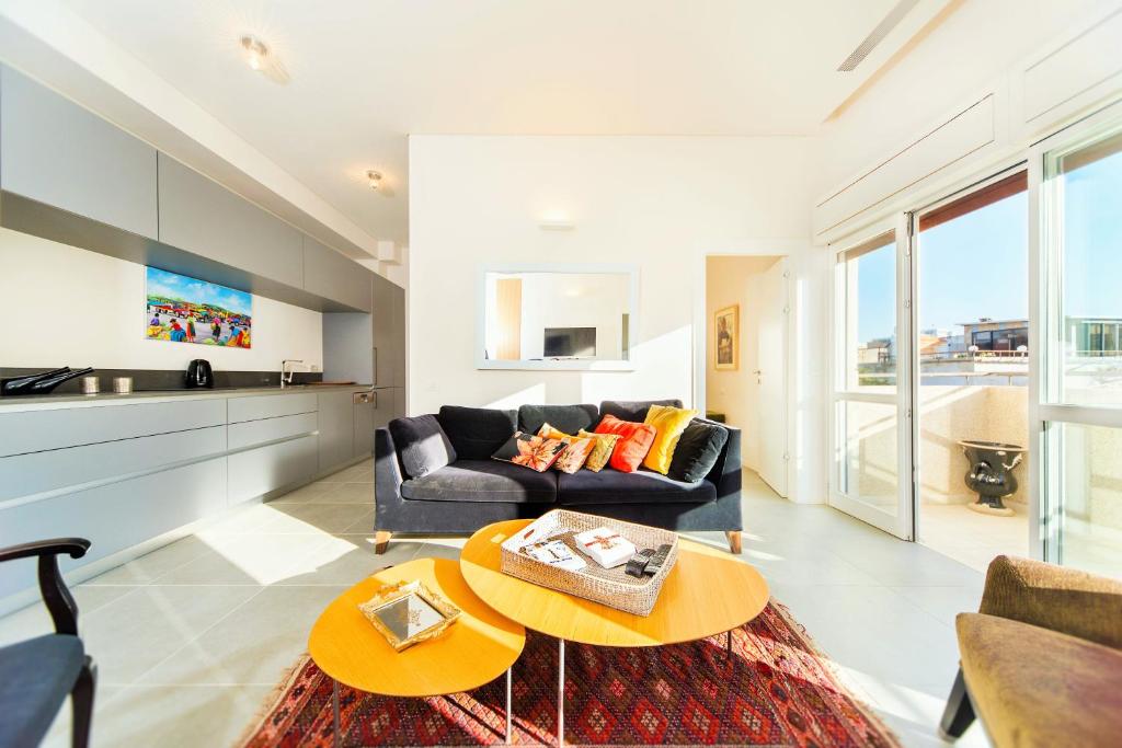 - un salon avec un canapé et une table dans l'établissement Bright 1BR Apartment w Balcony & Mamad 10 min Walk from Beach by Sea N' Rent, à Tel Aviv