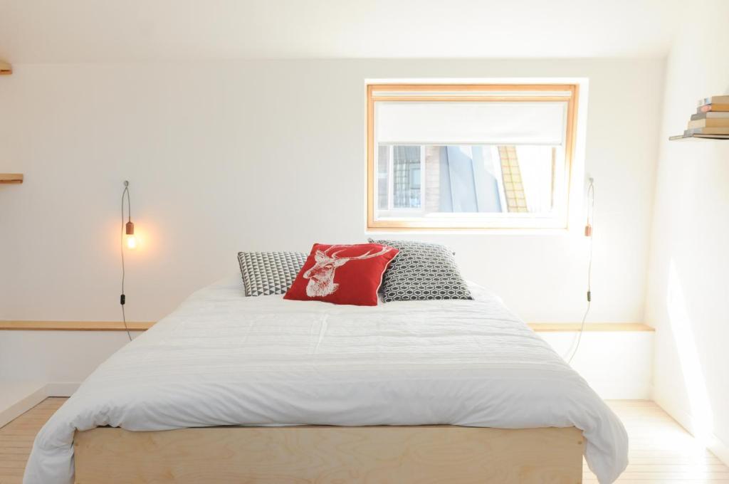 Un dormitorio con una cama con una almohada roja. en Huize Hertog, en Brujas