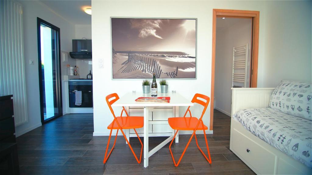 een kamer met een tafel, 2 stoelen en een bed bij Le Clos Maric in Séné