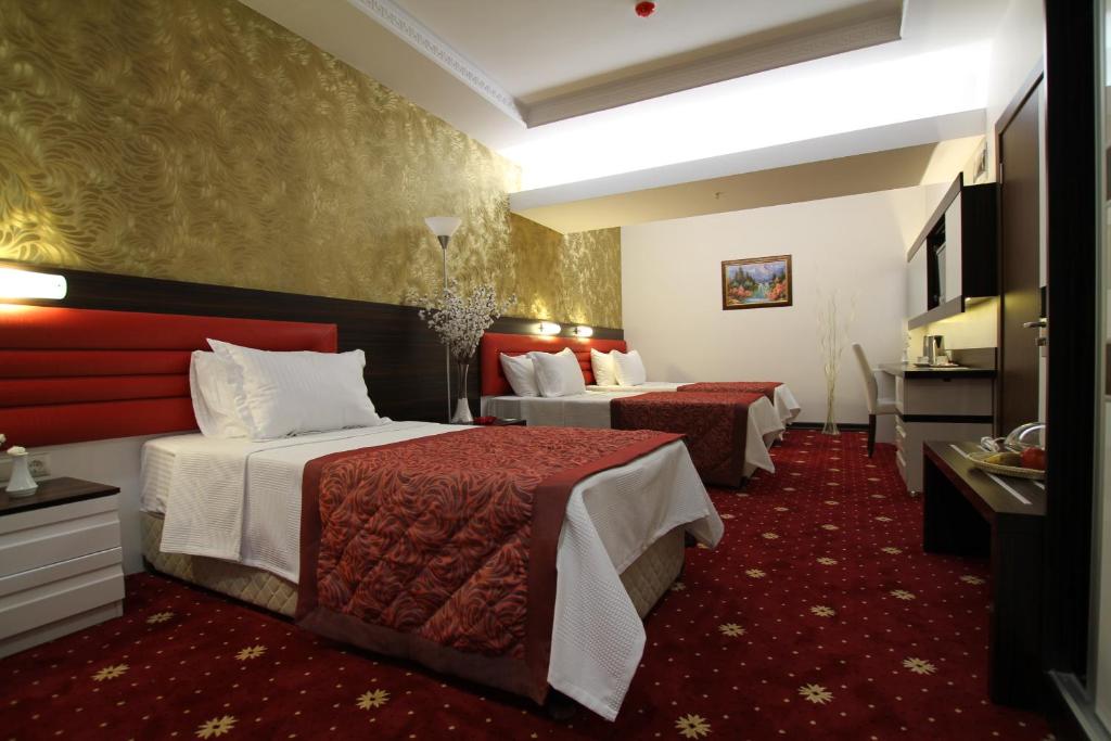 um quarto de hotel com duas camas e uma cozinha em Marwa Hotel em Eskisehir