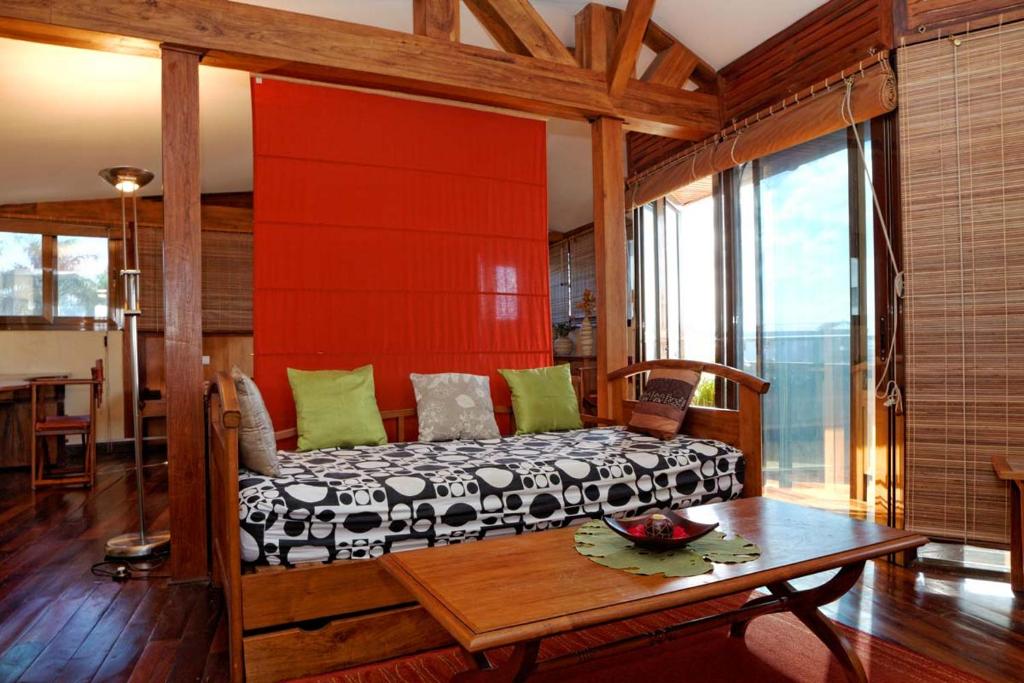 a bedroom with a bed with a wooden headboard and a table at Palm Hotel in Antananarivo