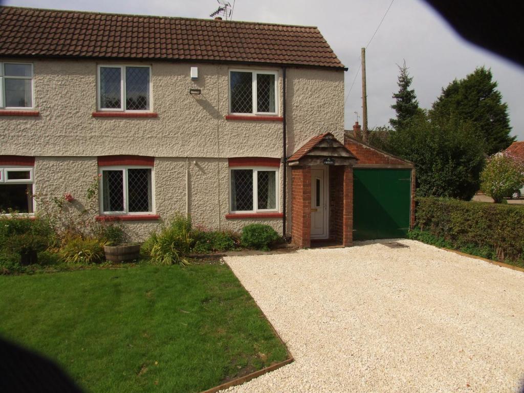 a house with a driveway and a green garage at firtrees in Selby