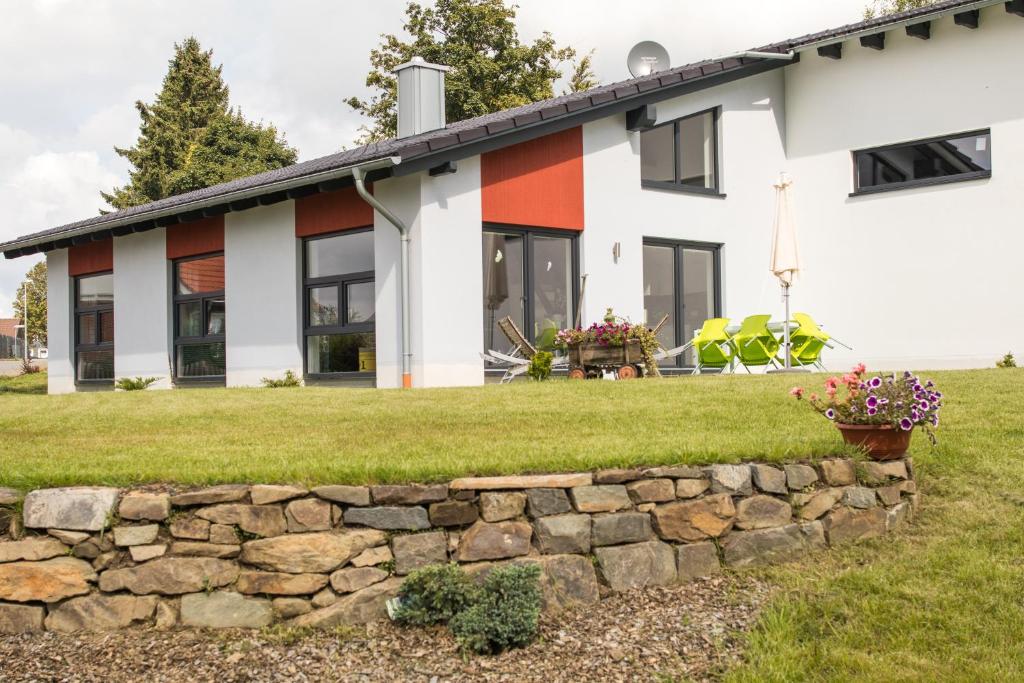 a house with a stone wall in front of it at Selke´s exklusives Ferienhaus in Clausthal-Zellerfeld