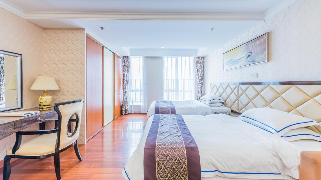 Habitación de hotel con 2 camas y escritorio en The Legend Nuomo Service Apartment, en Guangzhou