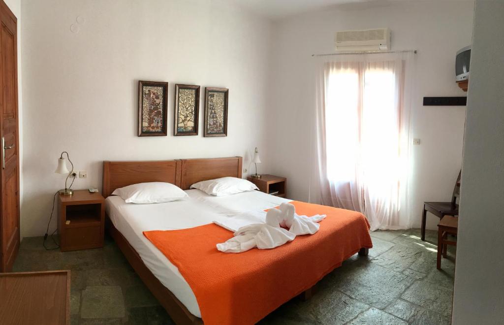 una camera da letto con un letto con un animale di peluche sopra di Antheia a Chora Folegandros