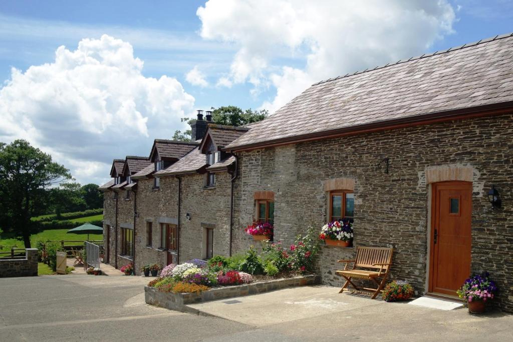 una fila de edificios de ladrillo con un banco y flores en Gwarffynnon, en Lampeter