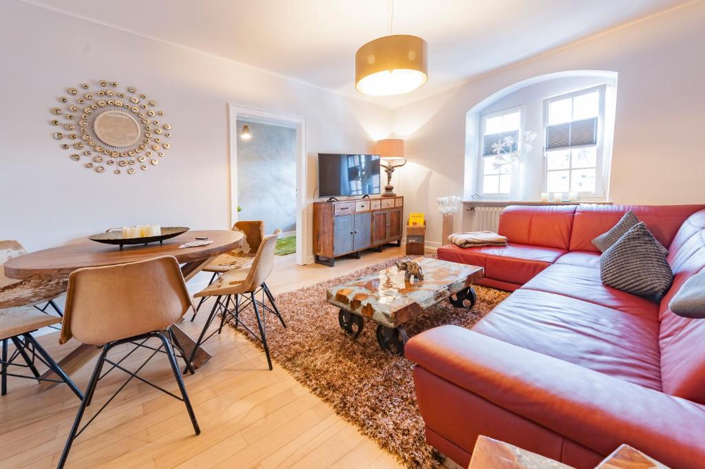 a living room with a red couch and a table at Holiday Trier City in Trier