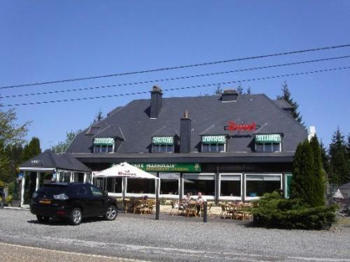 a black car parked in front of a building at Hotel Aux Massotais in Petites Tailles