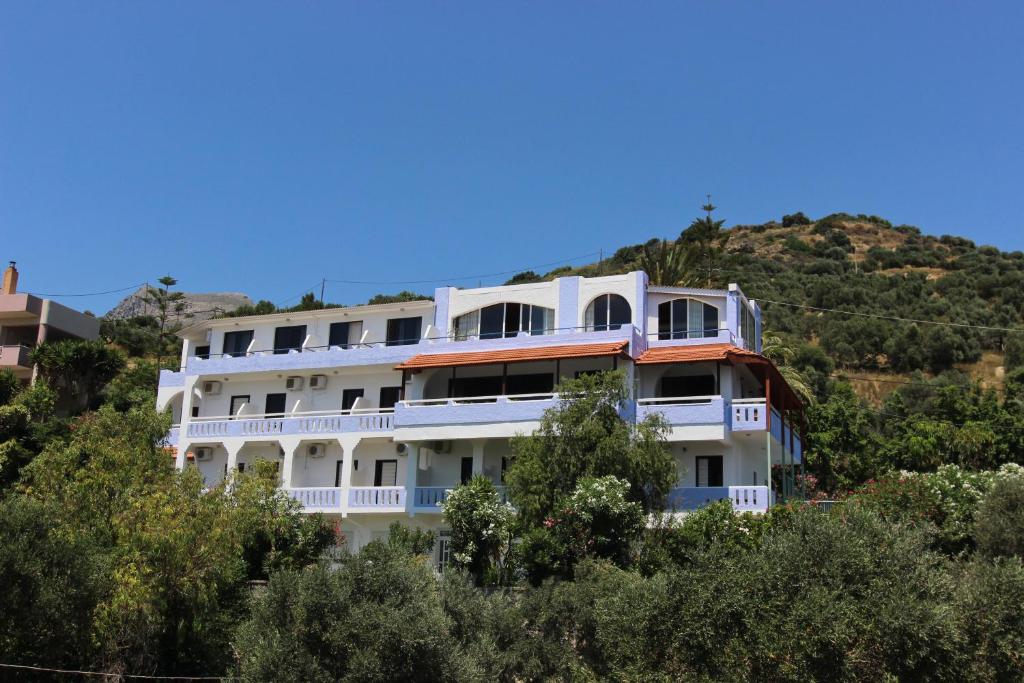 ein großes weißes Gebäude auf einem Hügel in der Unterkunft Lofos Hotel in Plakias