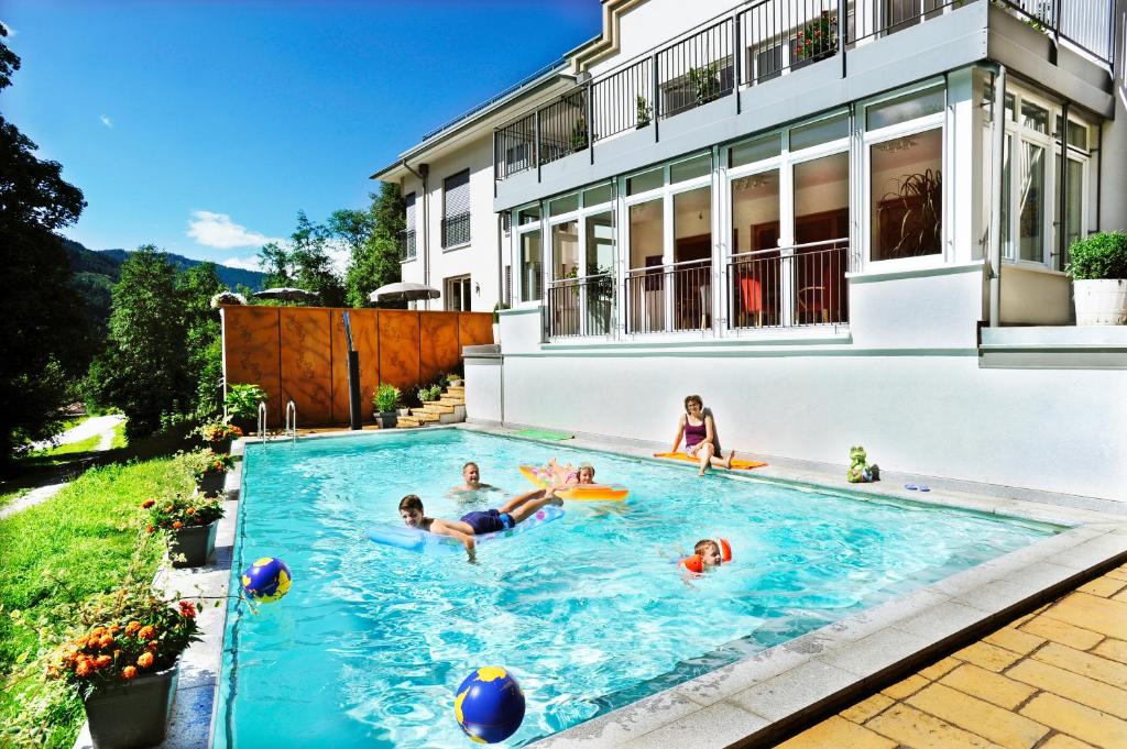 un grupo de personas en una piscina en una casa en Appartementhaus Mira Monti en Kleinarl