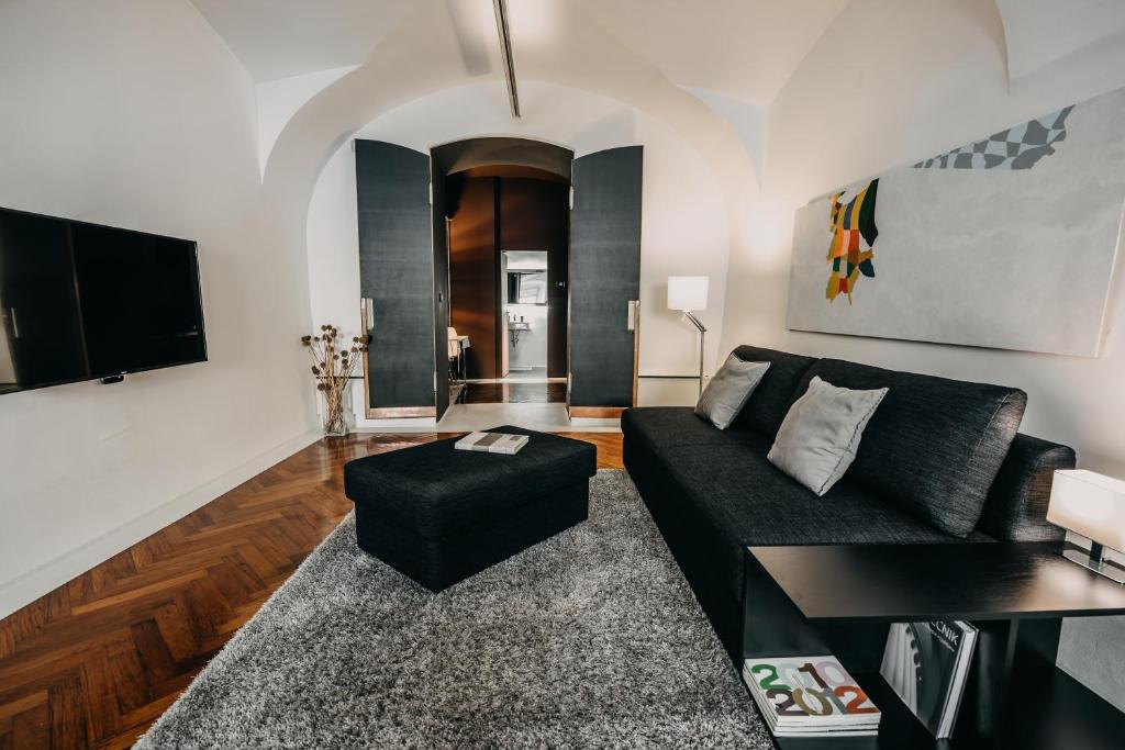 a living room with a black couch and a table at Mart's Choice Apartment in Ljubljana