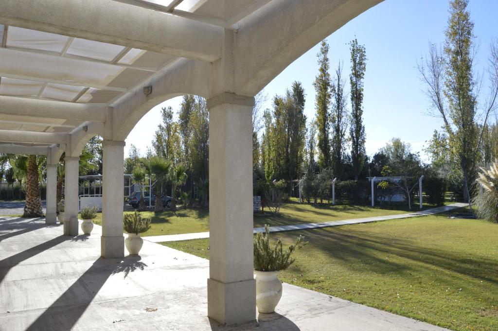 una pérgola blanca con macetas en un parque en Apart Hotel y Cabañas Olivos del Sol en San Juan