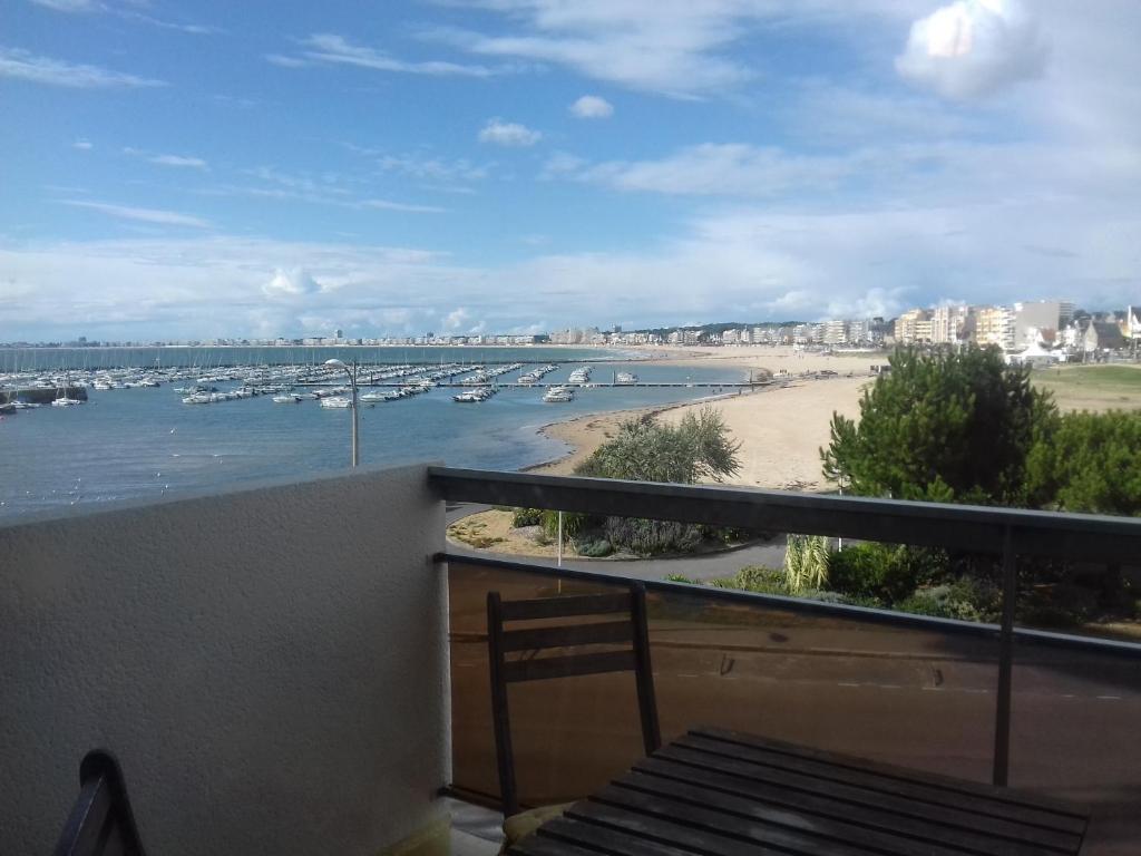 a balcony with a view of a beach and boats at Le Studio Galliéni vue panoramique face mer a fait peau neuve! in Pornichet