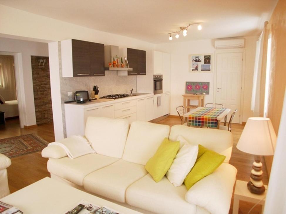a living room with a white couch and yellow pillows at Villa Franca in Grado