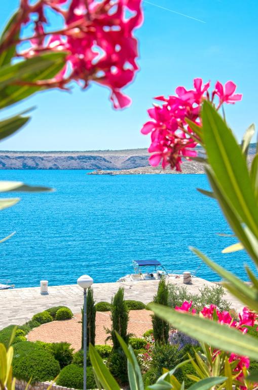 a view of a body of water with pink flowers at Apartmani Viktorija in Jadranovo