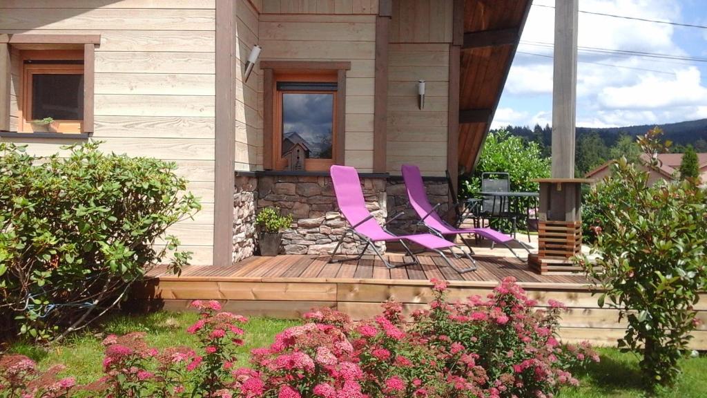 dos sillas rosas sentadas en el porche de una casa en Chalet la Petite Perle en Gérardmer