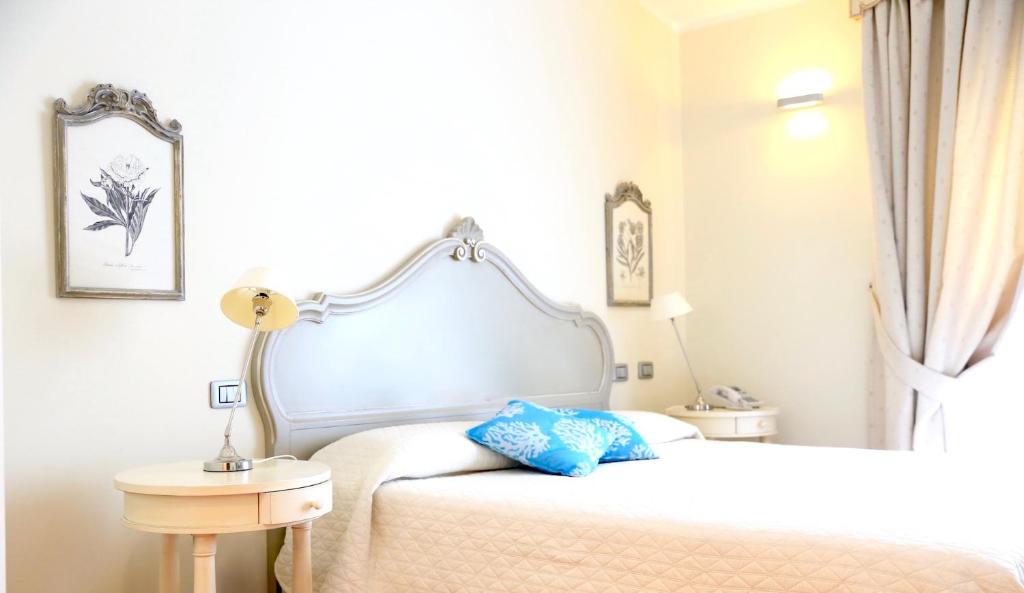 a bedroom with a white bed with a blue pillow on it at Villa Agnese in Sestri Levante