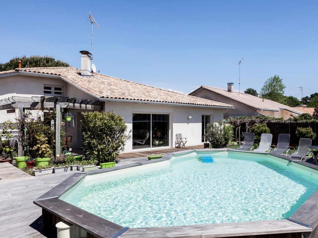 a swimming pool in the backyard of a house at Calme et Nature, BA in Gujan-Mestras