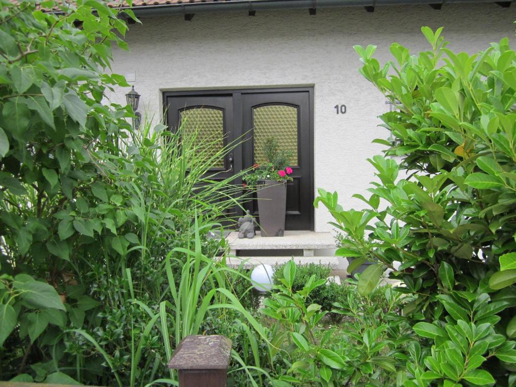 a house with a black door and some plants at Privatunterkunft Schonlau in Oberasbach