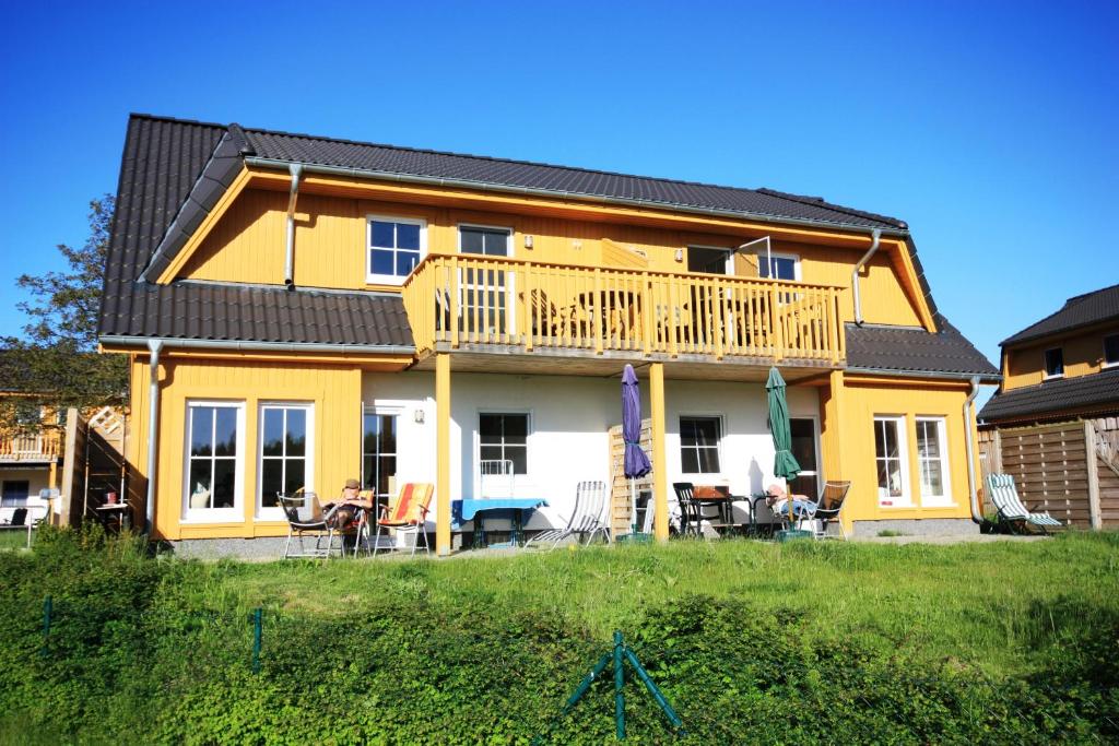 a yellow house with a deck on a hill at Ferienpark An der Seebrücke in Ostseebad Koserow