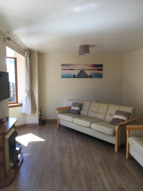 a living room with a white couch and a television at The Beachcomber in Inverallochy