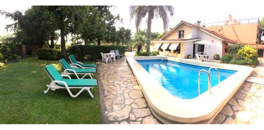 una piscina con 2 tumbonas y una casa en Green Hotel en Pilar