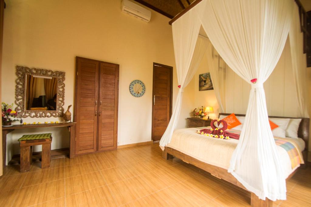 ウブドにあるVilla Ulun Mertha - 1BR Private Villaのベッドルーム(蚊帳付きのベッド付)