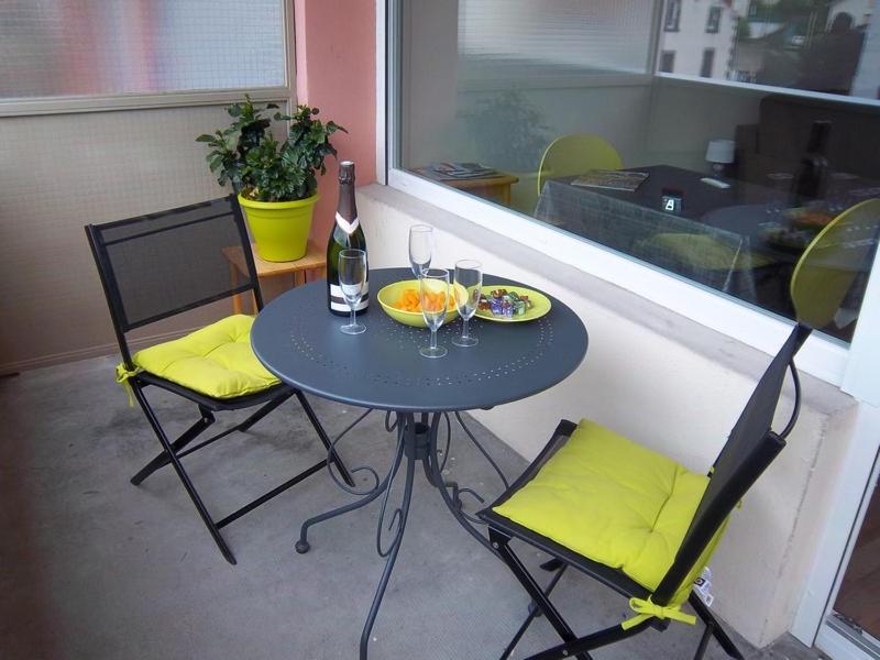 een tafel met twee stoelen en twee glazen wijn bij Résidence les Peupliers in Chamalières