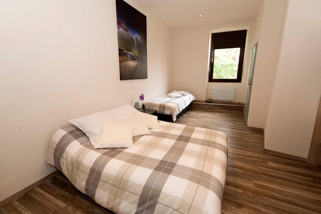 a bedroom with two beds in a room with wood floors at Hotel Restaurant de l'Europe in Wissembourg