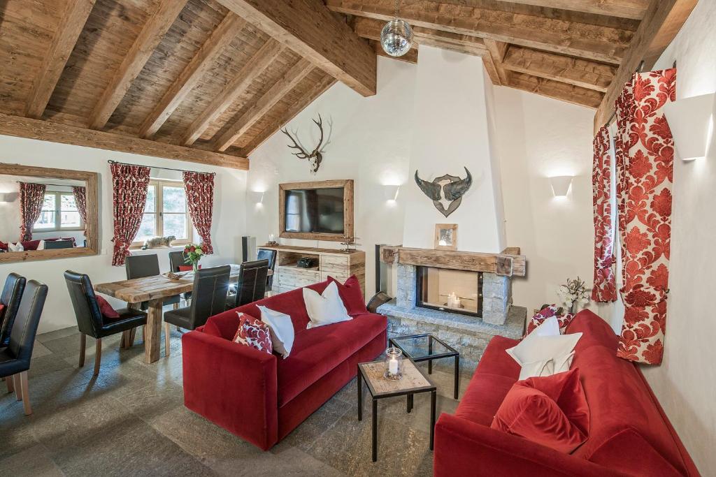 a living room with red furniture and a fireplace at Hotelino Petit Chalet in Celerina