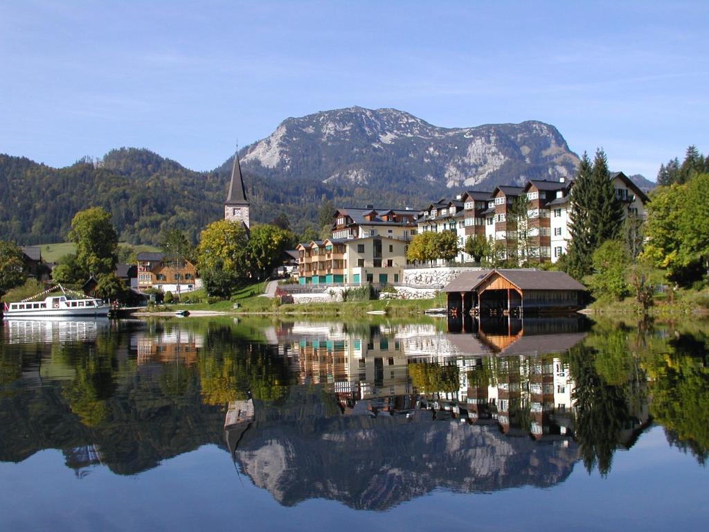 a town on a lake with a mountain in the background at Hotel am See - Seeresidenz in Altaussee