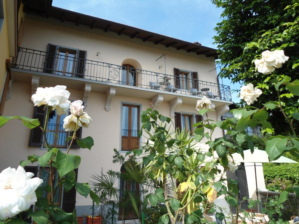 un edificio blanco con balcones y flores en Casa Bureglio en Verbania