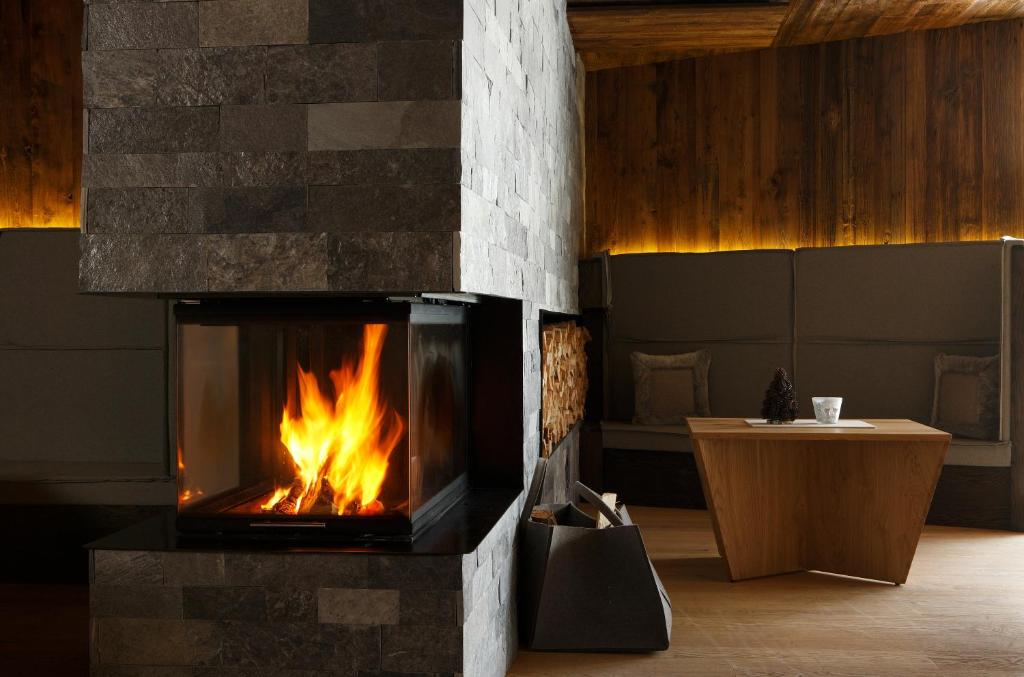 a fireplace in the middle of a room at Hotel Col Alto in Corvara in Badia