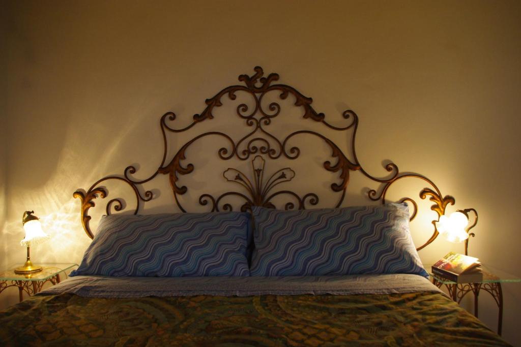 uma cama com uma cabeceira ornamentada num quarto em Charming apartment em Siena
