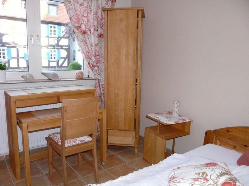 um quarto com uma secretária, uma cama e uma janela em Kleines Stadthaus Grünberg em Grünberg