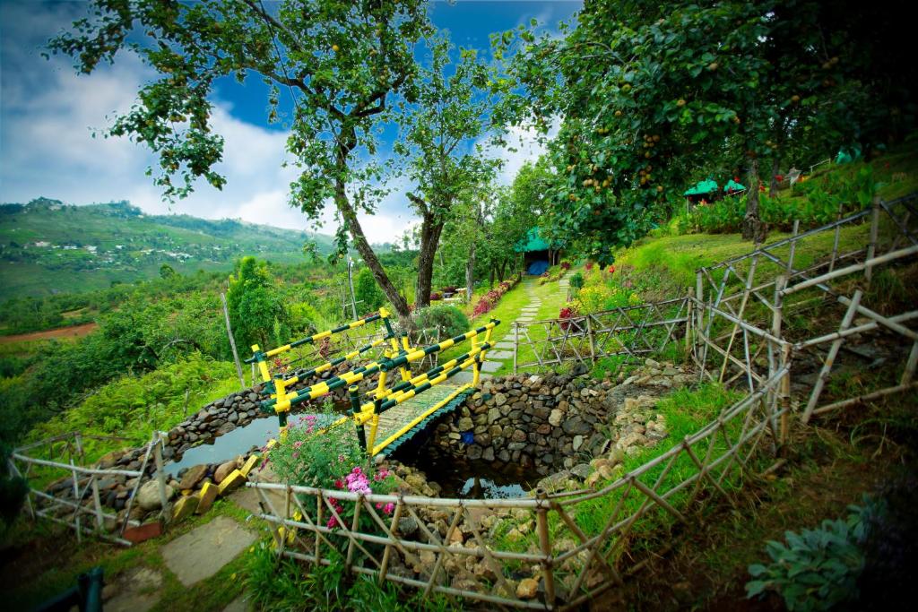 un grupo de bancos amarillos sentados en la cima de una colina en The Pear County, en Kodaikanal