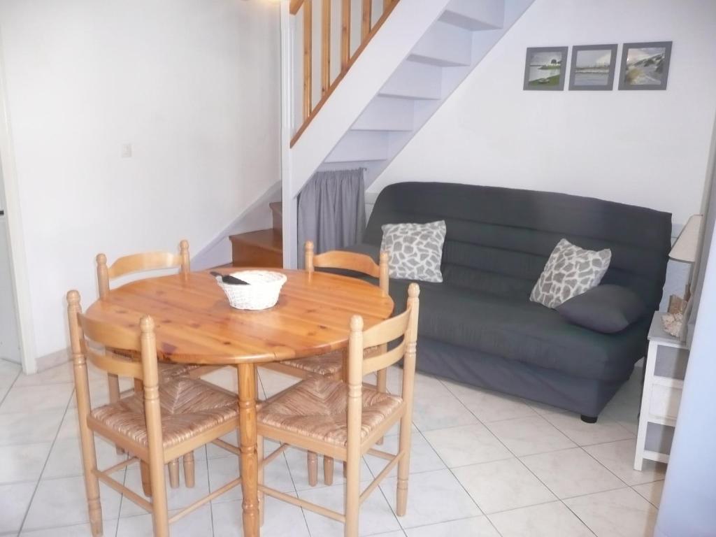 een eetkamer met een tafel en een bank bij Escale Baie de Somme in Saint-Valery-sur-Somme