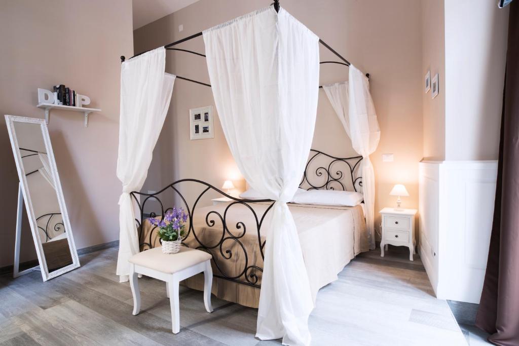 Habitación con cama con cortinas y mesa. en Dimora Partenopea, en Nápoles
