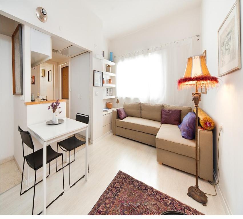 uma sala de estar com um sofá e uma mesa em Cozy 1 BR Apt Only a 5 Minute Walk from the Beach by Sea N' Rent em Tel Aviv