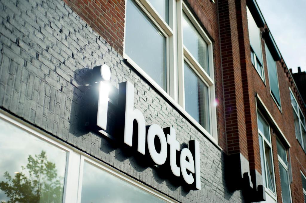 a hotel sign on the side of a brick building at i hotel in Amsterdam