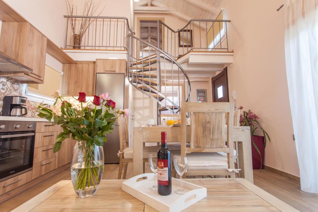 a kitchen with a table with a bottle of wine and flowers at Villa Rigilis in Nydri