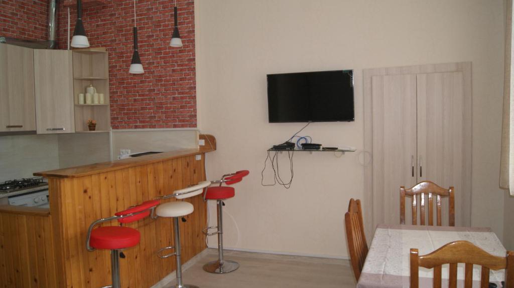 eine Küche mit einem Tisch und einem TV an der Wand in der Unterkunft Modern Apartment Avlabari in Tbilisi City