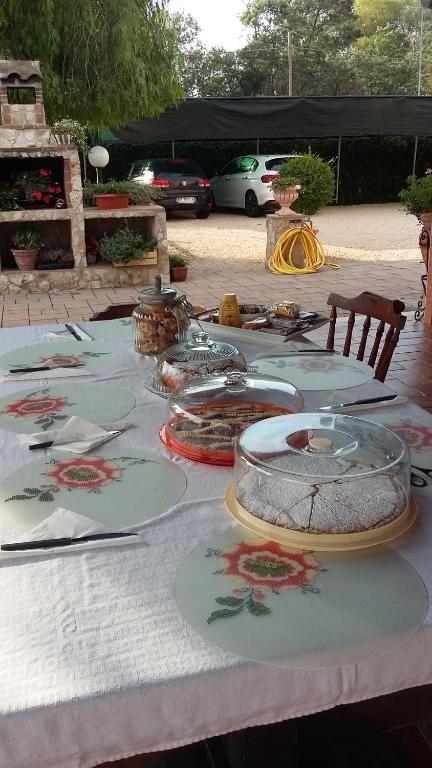 a table with a white table cloth with food on it at Casale Del Borgo in Hermada